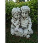 Jongen en meisje aan het lezen liggend tuinbeeld